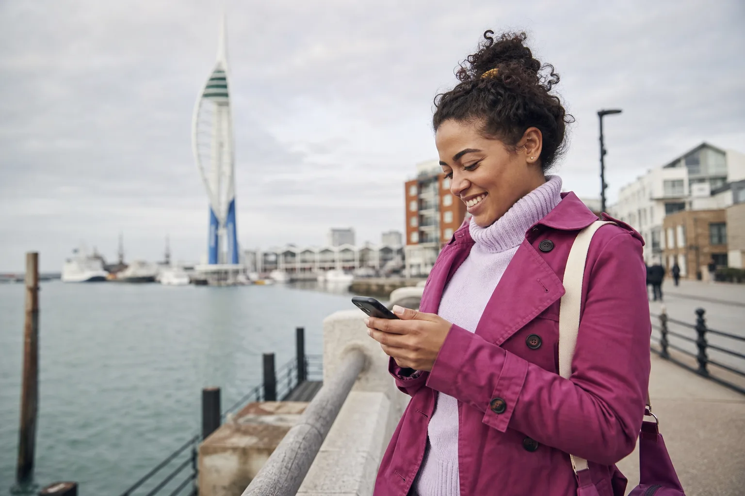 Person creating a dating profile on a phone beside Southsea seafront in Portsmouth